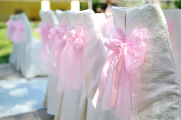 Beautiful chairs with pink bows on wedding ceremony — Stock Photo, Image