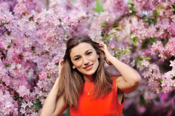 Beautiful young girl in the park and a flowering tree — Stock Photo, Image