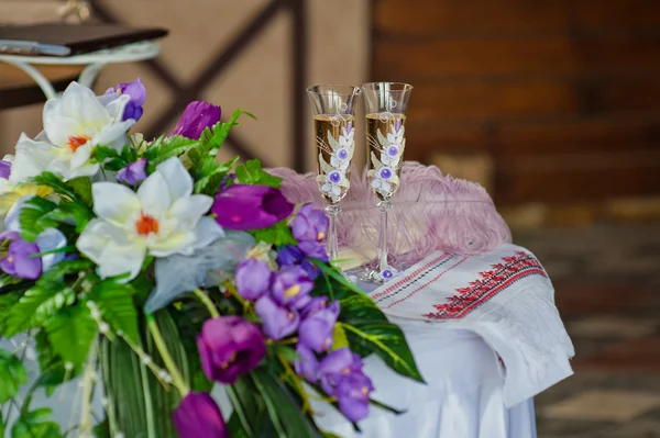 Два свадебных бокала и свадебный букет на камне в летнем саду — стоковое фото