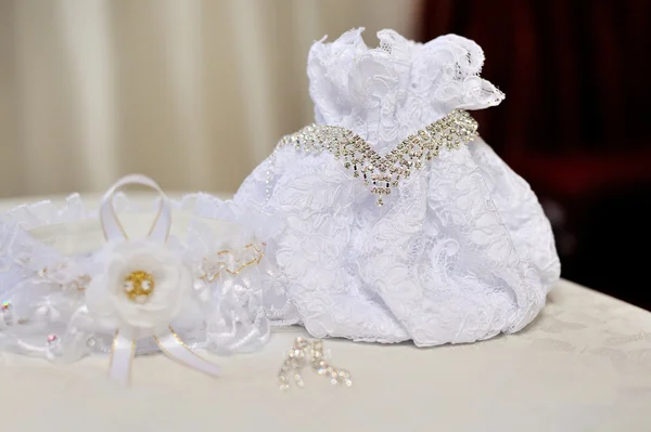 Wedding bride's handtas, ketting en oorbellen liggen op tafel — Stockfoto