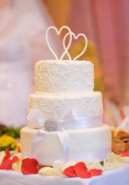 Gâteau de mariage blanc à plusieurs niveaux avec deux cœurs au-dessus — Photo