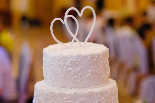 Bolo de casamento branco multi-camadas com dois corações acima — Fotografia de Stock