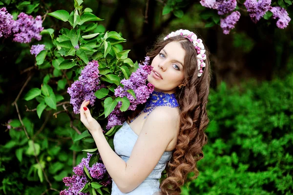 Ritratto di giovane donna vicino alla fioritura lilla — Foto Stock