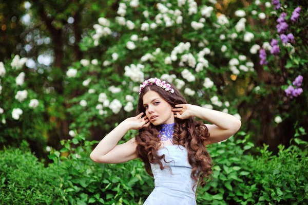 Retrato de mulher jovem perto do lilás florescente — Fotografia de Stock