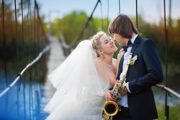 Bruid en bruidegom permanent op de brug — Stockfoto