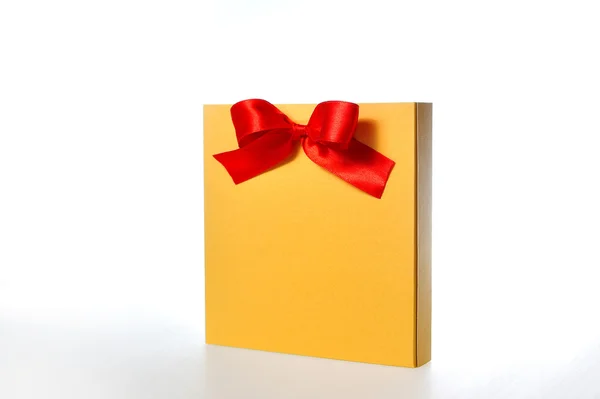 Uroczysty złoto pudełko z kokardą czerwony na białym tle — Zdjęcie stockowe