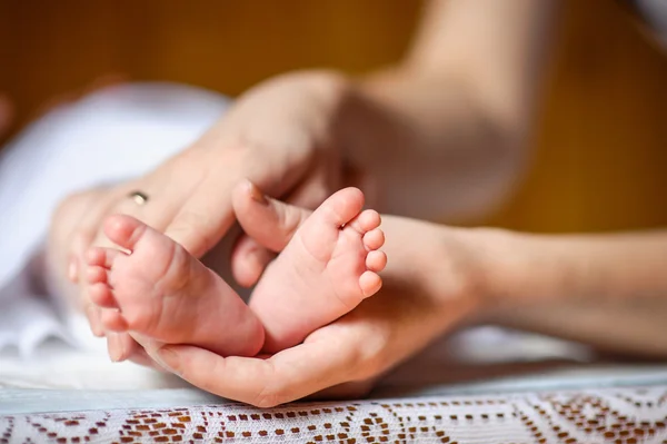 刚出生的婴儿脚在母亲的手中 — 图库照片