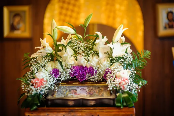 Hochzeitsaccessoires und Interieur im orthodoxen Kloster der Heiligen Dreifaltigkeit, darunter zwei Kerzenständer mit vielen Kerzen, Blumen, Ikonen und der Heiligen Bibel. wunderschöne Kirche in Riga, Lettland — Stockfoto