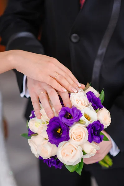 新郎和新娘在婚礼的花束上的手 — 图库照片