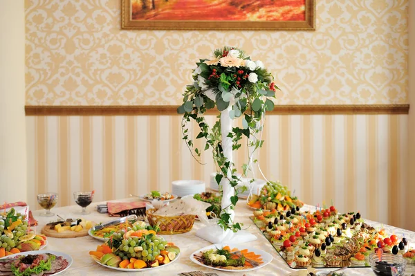 Tabel set voor bruiloft diner versierd met bloemen — Stockfoto