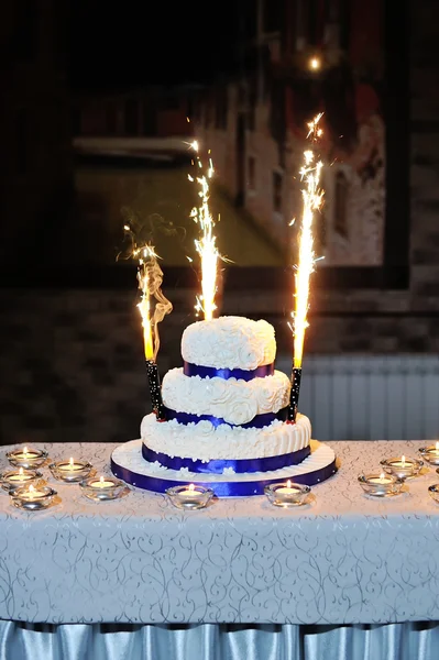 Belo bolo de casamento em uma mesa com velas — Fotografia de Stock