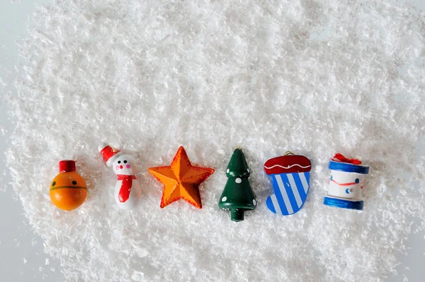 雪の白い背景の上のクリスマスのおもちゃ — ストック写真