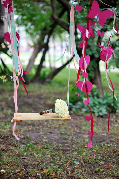 Bridal bouquet on swing — Stock Photo, Image