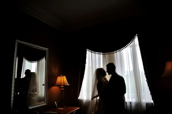 Silhouettes of the bride and groom on the background of a window — Stock Photo, Image