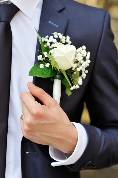 Rose blanche boutonnière sur costume du marié — Photo