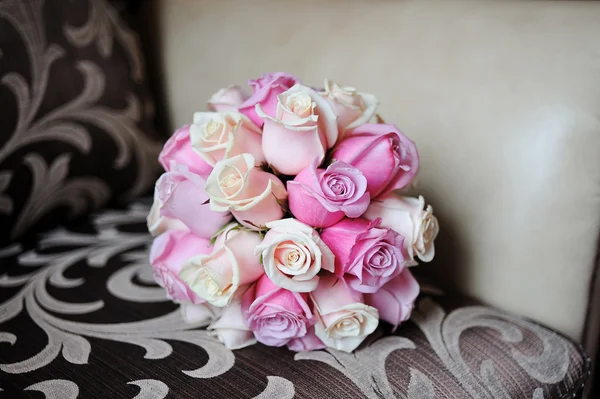 Wedding bouquet of pink roses lying on the sofa Stock Photo