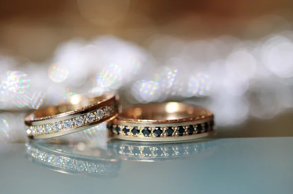 Zlaté snubní prsteny položil na stůl — Stock fotografie
