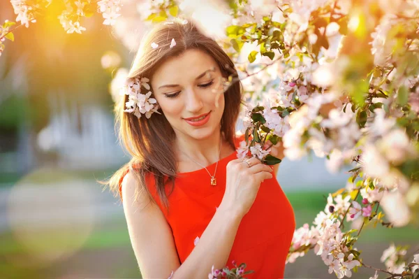 Menina bonita em um passeio entre as árvores florescentes — Fotografia de Stock