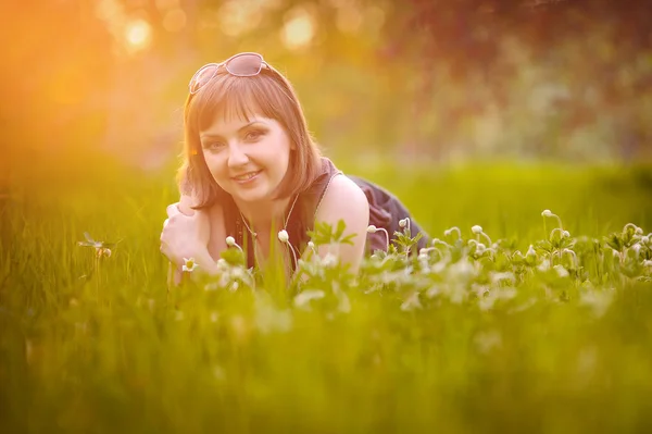 太陽の下で草の上に横たわる美しい少女 — ストック写真