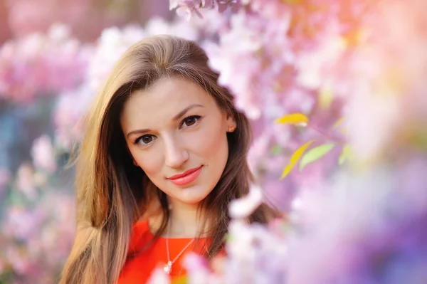 Retrato de una mujer bonita cerca del árbol florecido en el parque. Concepto de juventud y belleza natural —  Fotos de Stock