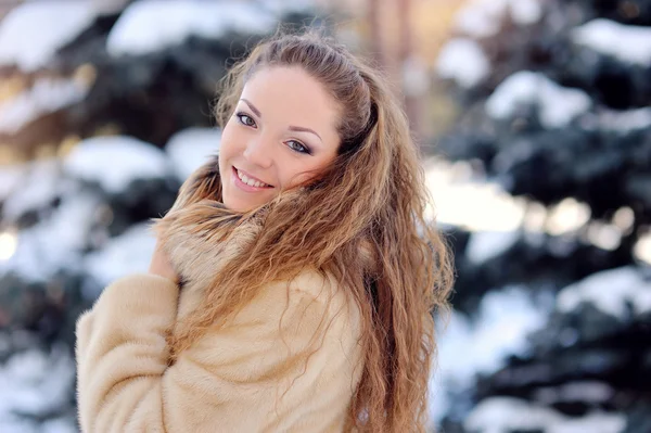 Beautiful girl on the street near fir-tree in winter — Stock Photo, Image