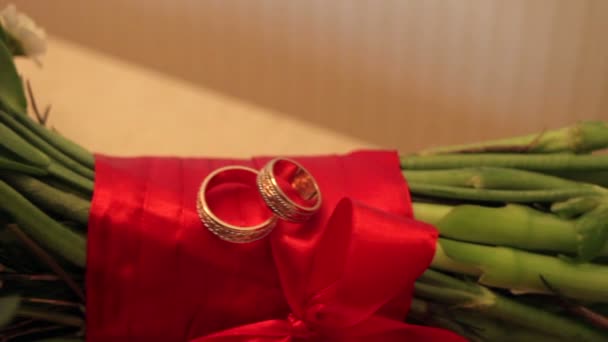 Bouquet de roses rouges et anneaux de mariée sur la table — Video