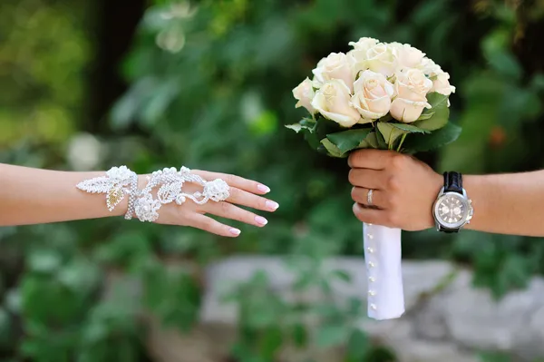 Pan młody przenosi dać panny młodej bukiet ślubny z białych róż — Zdjęcie stockowe