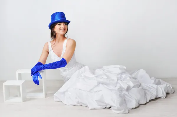 Happy bride duduk di lantai dengan topi biru dan sarung tangan biru , — Stok Foto