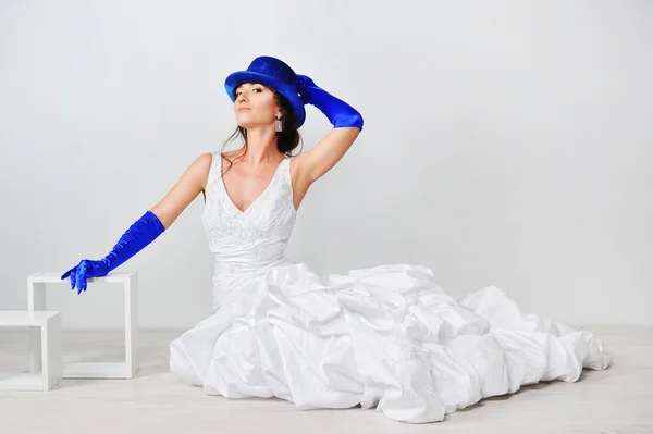 Красивая девушка в белом платье в голубой шляпе на белом фоне — стоковое фото
