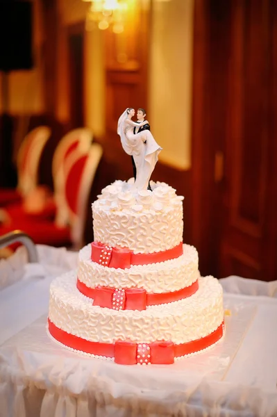 Pastel de boda blanco de tres niveles con cintas rojas —  Fotos de Stock