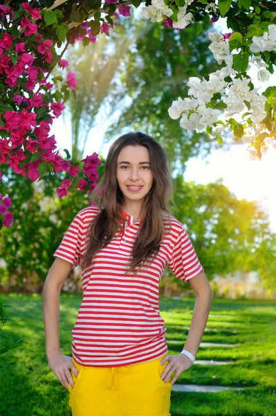 Schöne Sinnlichkeit junges Mädchen auf einem Hintergrund von Blumen — Stockfoto