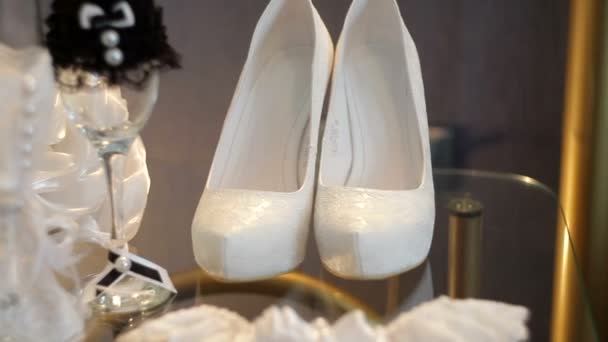 白いブライダル靴とテーブルの上の結婚式のアクセサリー — ストック動画