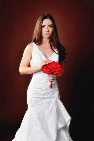 Красивая девушка в свадебном платье с букетом — стоковое фото