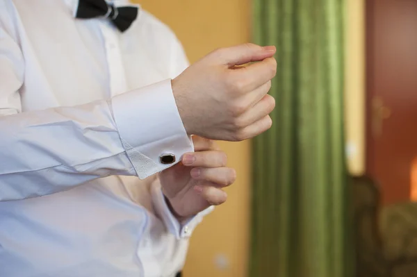 Man zet manchetknopen op shirts mouwen wit — Stockfoto
