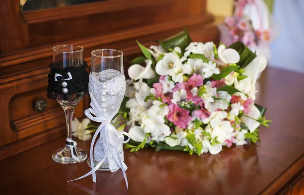 Mooie bruiloft boeket en twee glazen met champagne — Stockfoto
