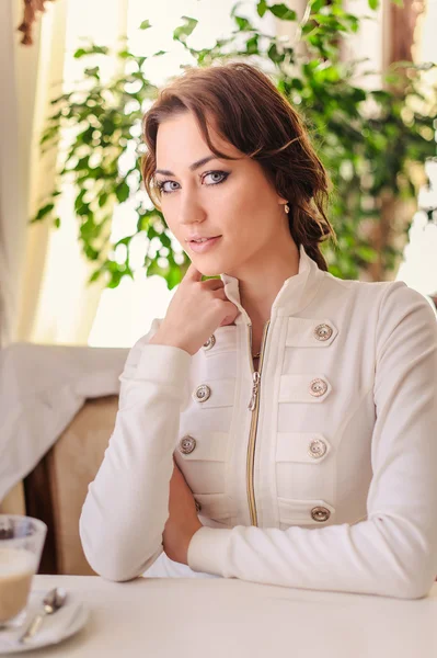 Beautiful girl sitting at table — Stock Photo, Image