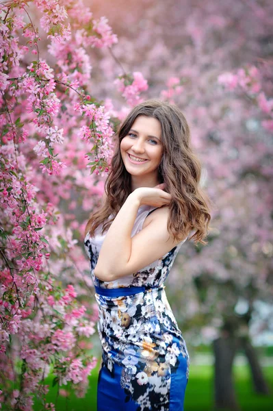 Retrato de uma linda menina morena no jardim florido — Fotografia de Stock