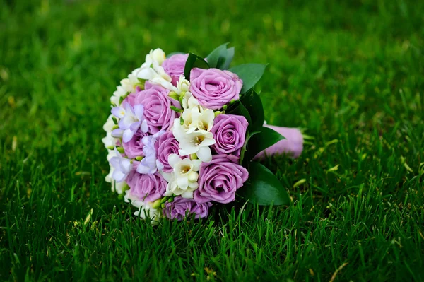 Beautiful wedding bouquet t lie on the grass — Stock Photo, Image
