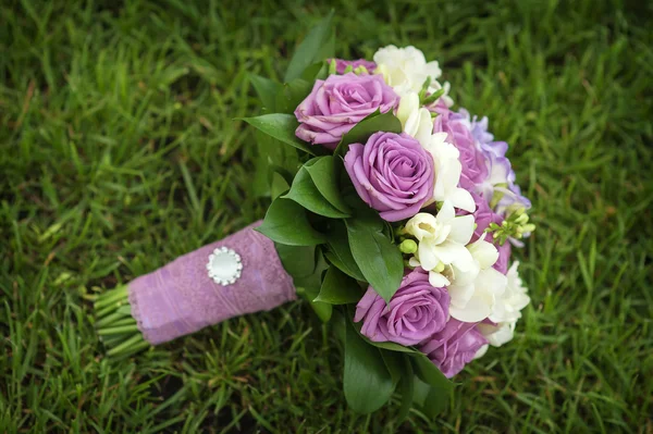 Buquê de casamento de flores deitado na grama verde — Fotografia de Stock