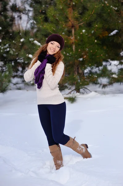 Mooi meisje permanent op achtergrond winter bomen — Stockfoto