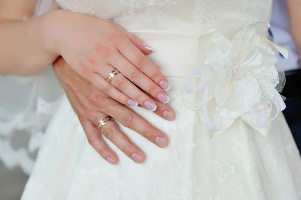 Las manos de una novia y un novio con anillos de boda de oro — Foto de Stock