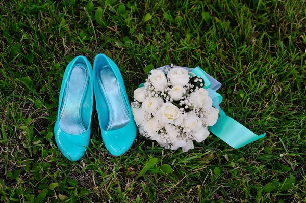 Buquê de noiva e sapatos turquesa na grama verde Imagem De Stock
