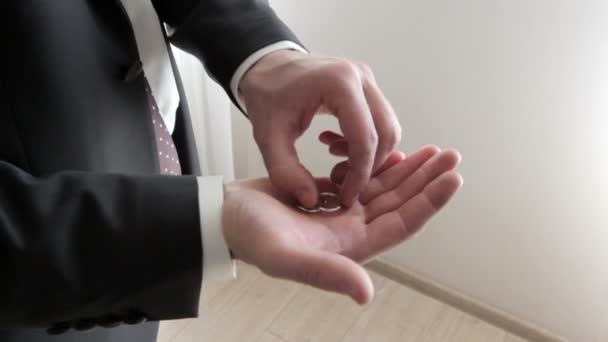 Hombre con traje sosteniendo dos anillos de boda — Vídeos de Stock