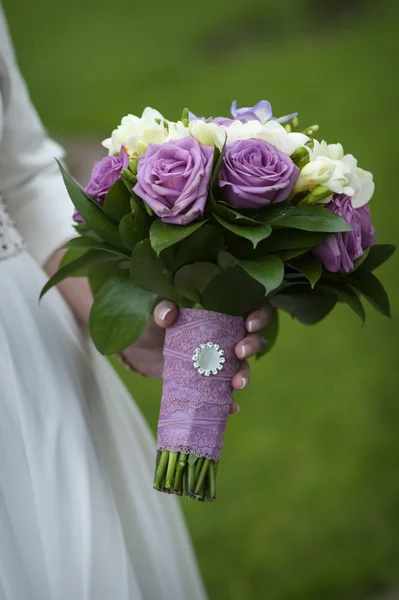 Bukiet ślubny z purpurowe i białe róże w rękach panny młodej — Zdjęcie stockowe