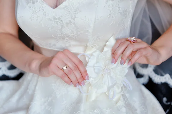 Bride adjusts white bow on her dress — Stock Photo, Image