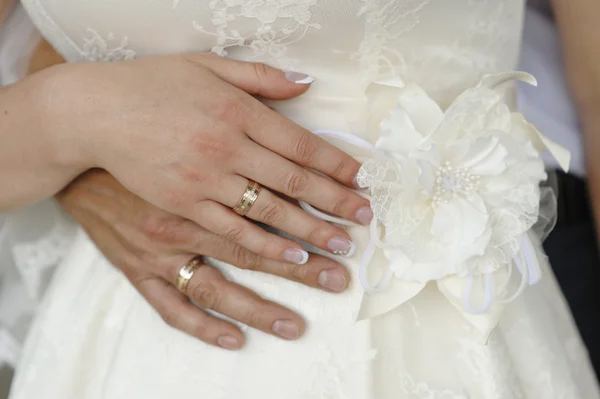 Manos de la novia y el novio con anillos en un vestido blanco — Foto de Stock