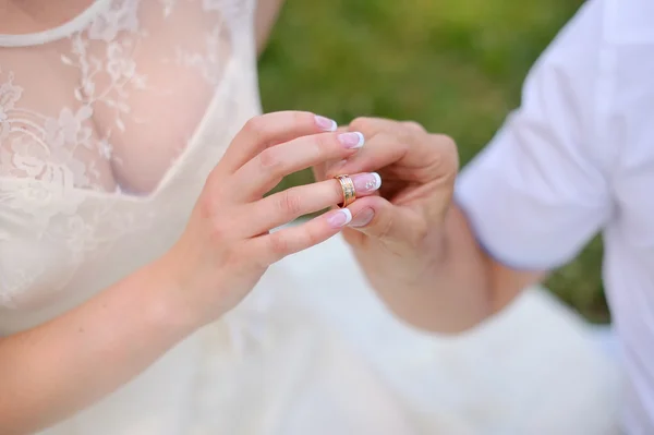 El novio joven lleva la novia del anillo. Aislado sobre fondo blanco — Foto de Stock