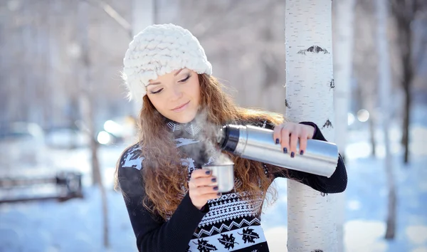 美しいブルネット冬散歩魔法瓶からコーヒーを注ぐ — ストック写真