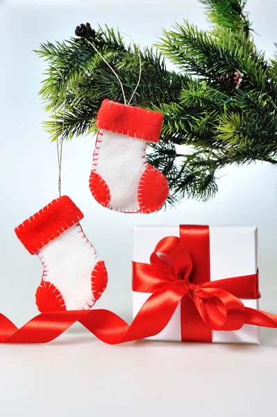 Красиві подарункові коробки з червоними стрічками і гілки дерев на білому фоні — Stok fotoğraf