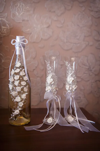 Dekorierte Hochzeitsgläser und eine Flasche Champagner — Stockfoto